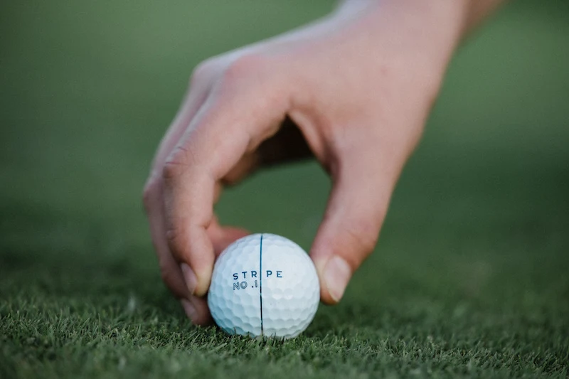 Golf ball aligned with a stripe