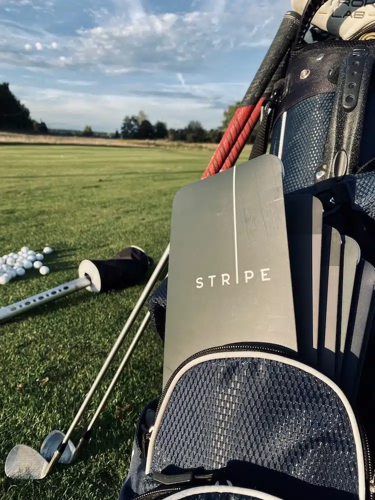Golfträning på gräs range med golfhandske från stripe golf